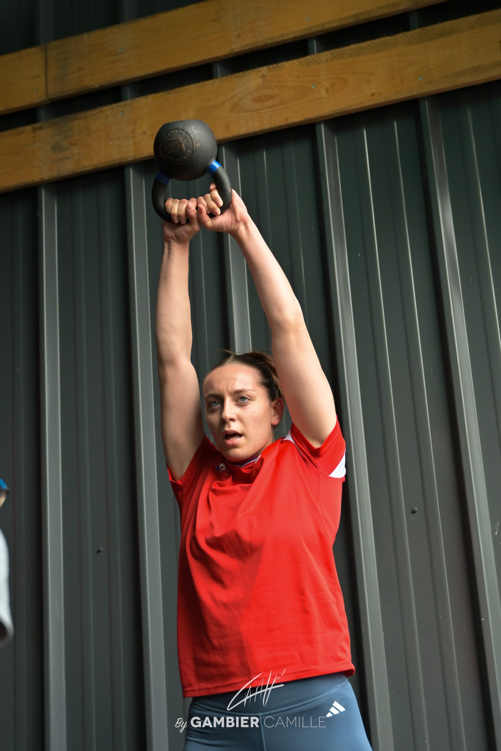 evement sportif à vichy de crossfit femme tenant un kettlebell au dessus de la tête