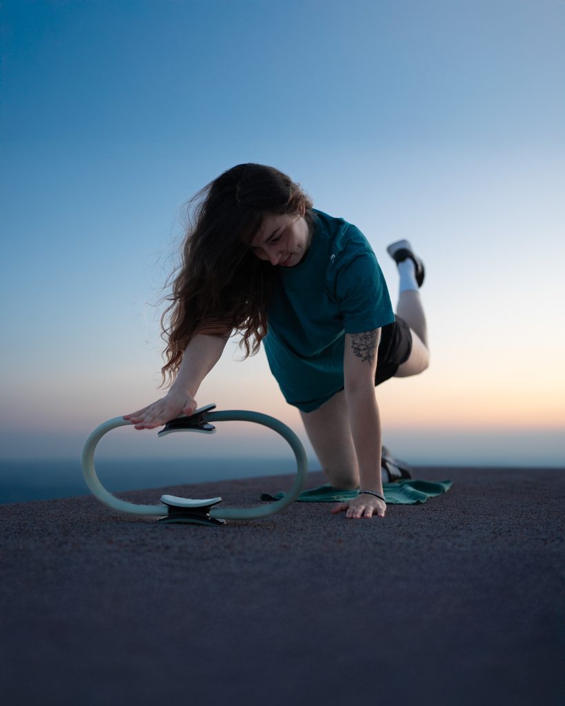 Femme avec un anneau de Pilates au coucher du soleil en Auvergne Femme avec un anneau de Pilates au coucher du soleil en Auvergne