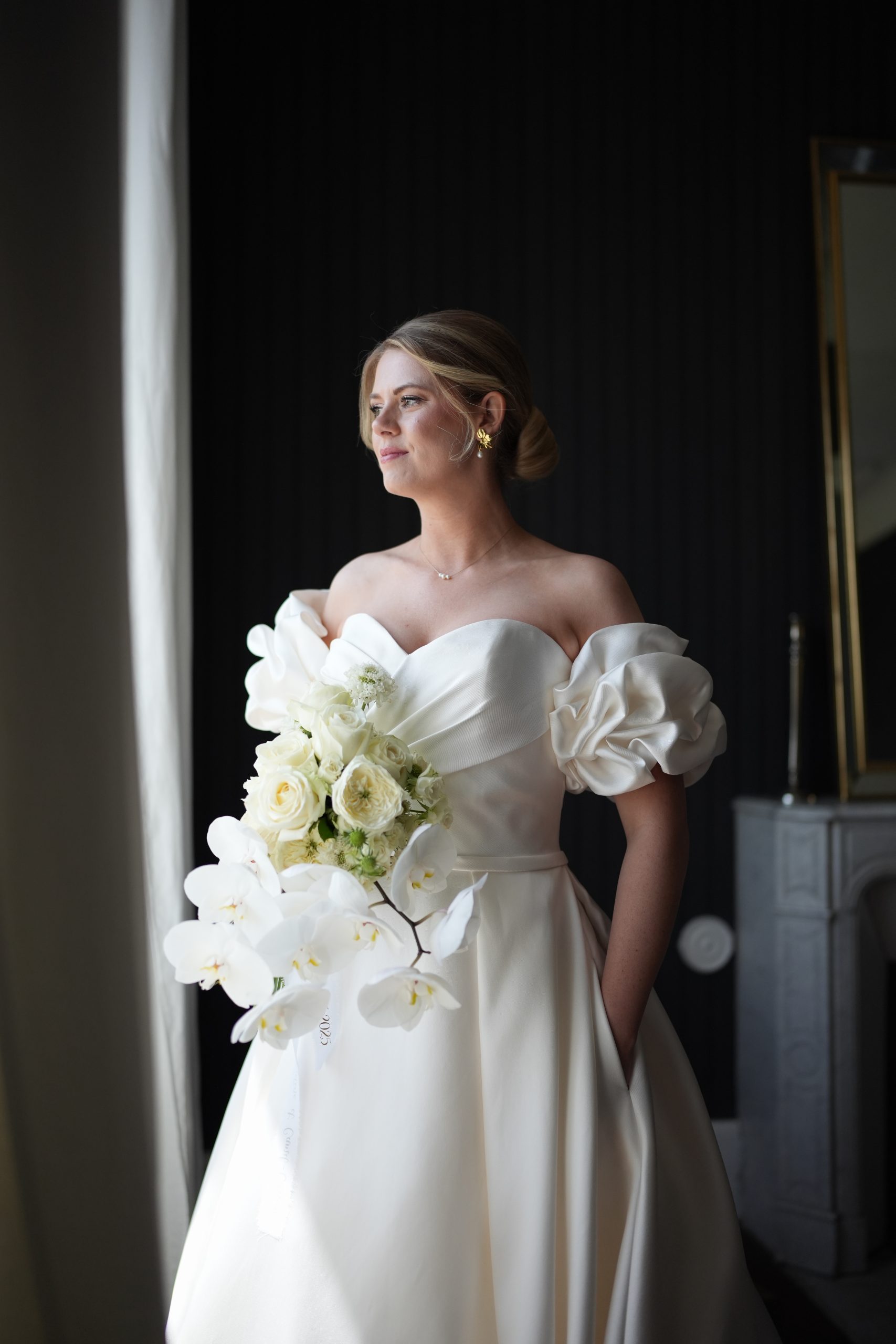 Mariée pendant ses préparatifs au Château d’Aine à Aize, juste après avoir enfilé sa robe, captée dans un style naturel et cinématographique avant la découverte avec le marié.