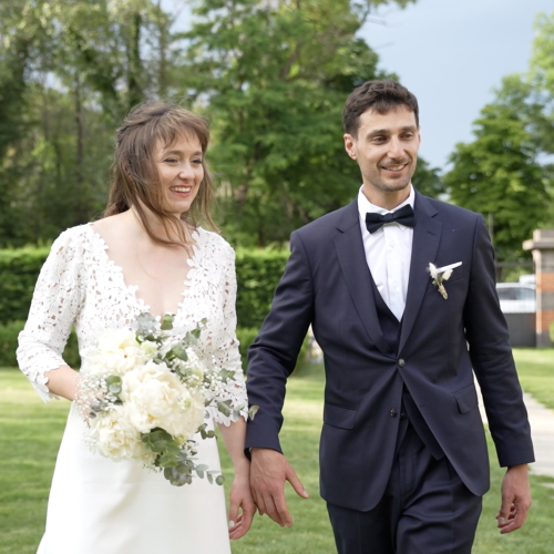 Jeune couple de marié souriant se tiennent la main dans un parc