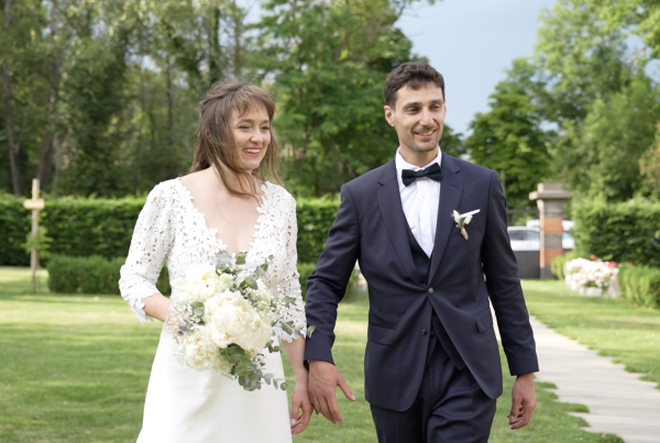 Jeune couple de marié souriant se tiennent la main dans un parc