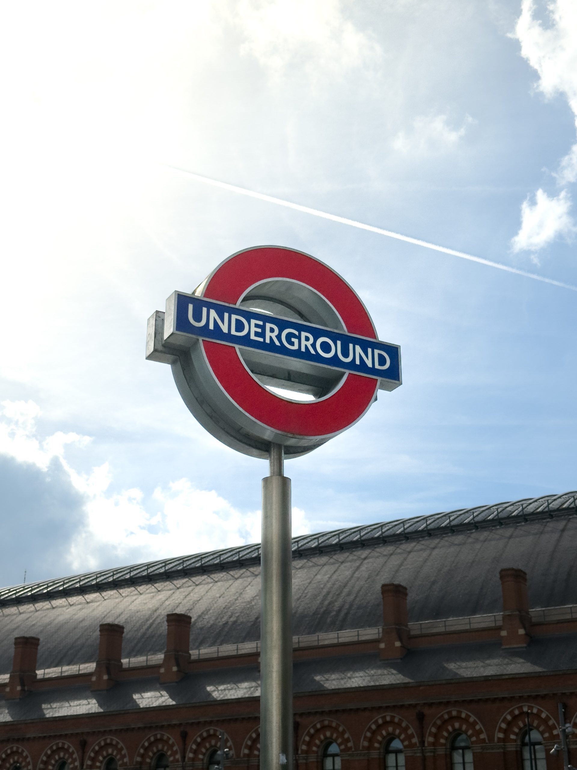 Panneau métallique underground à Londres avec un ciel bleu nuageux