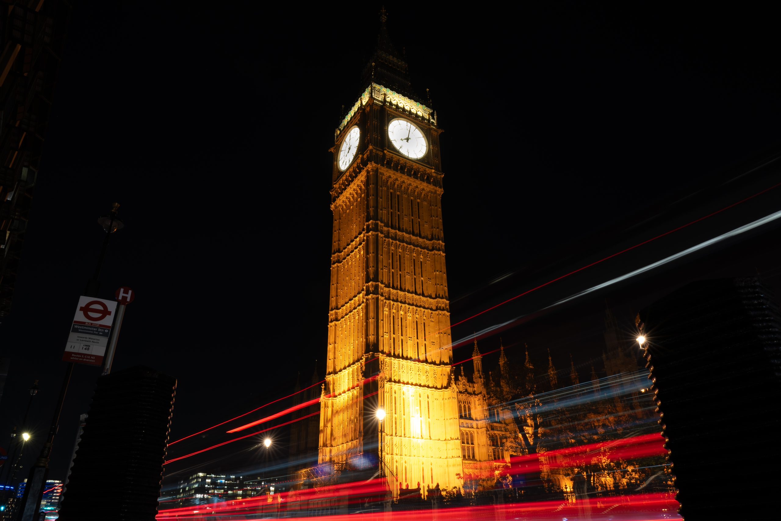 Big Ben à Londres de nuit avec effet motion blur des bus rouges
