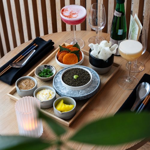 plat de ramen posé sur une table avec des cocktails